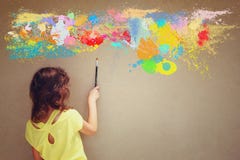 El cepillo lindo de la tenencia del niño de la visión trasera al lado de la pared y de la pintura texturizadas salpica fotografía de archivo El cepillo lindo de la tenencia del niño de la visión trasera al lado de la pared y de la pintura texturizadas salpica fotografía de archivo