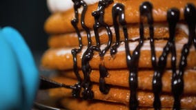 El chef de repostería vierte el chocolate líquido en theof la torta para adornarla imagen de archivo libre de regalías El chef de repostería vierte el chocolate líquido en theof la torta para adornarla imagen de archivo libre de regalías
