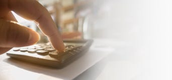 El cierre de la mano humana está consumiendo la calculadora imagenes de archivo El cierre de la mano humana está consumiendo la calculadora imagenes de archivo