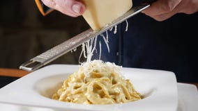 El cocinar de la comida del restaurante Queso el rallar del cocinero en el rallador de acero que prepara las pastas con los maris metrajes El cocinar de la comida del restaurante Queso el rallar del cocinero en el rallador de acero que prepara las pastas con los maris metrajes