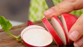 El cocinero corta el rábano en rebanadas almacen de metraje de vídeo El cocinero corta el rábano en rebanadas almacen de metraje de vídeo