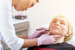 El cosmetólogo empuja una jeringuilla para inyectar Botox foto de archivo El cosmetólogo empuja una jeringuilla para inyectar Botox foto de archivo