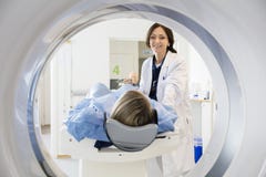 El doctor de sexo femenino Looking At Patient que experimenta la exploración del CT imágenes de archivo libres de regalías El doctor de sexo femenino Looking At Patient que experimenta la exploración del CT imágenes de archivo libres de regalías