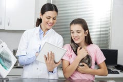 El doctor Showing Tablet Computer a la muchacha que sostiene la comadreja imágenes de archivo libres de regalías El doctor Showing Tablet Computer a la muchacha que sostiene la comadreja imágenes de archivo libres de regalías