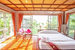 El dormitorio brillante y espacioso, ventana amplia, piso de madera, palmeras cultiva un huerto exterior Estilo tropical de relaj imágenes de archivo libres de regalías El dormitorio brillante y espacioso, ventana amplia, piso de madera, palmeras cultiva un huerto exterior Estilo tropical de relaj imágenes de archivo libres de regalías