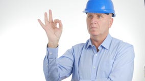 El encargado Wearing Engineer Helmet hace buena muestra del trabajo gestos de mano ACEPTABLES foto de archivo libre de regalías El encargado Wearing Engineer Helmet hace buena muestra del trabajo gestos de mano ACEPTABLES foto de archivo libre de regalías
