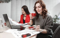 El equipo de dise?ador de dos mujeres jovenes est? trabajando en el proyecto de dise?o de la sentada interior en el escritorio co foto de archivo libre de regalías El equipo de dise?ador de dos mujeres jovenes est? trabajando en el proyecto de dise?o de la sentada interior en el escritorio co foto de archivo libre de regalías