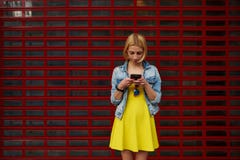 El estudiante femenino del inconformista en el vestido usando el teléfono móvil para conecta con la radio Imagenes de archivo El estudiante femenino del inconformista en el vestido usando el teléfono móvil para conecta con la radio Imagenes de archivo
