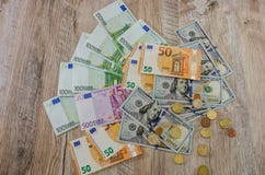 El euro, d?lares, centavos se separ? hacia fuera en un fondo de madera fotografía de archivo libre de regalías El euro, d?lares, centavos se separ? hacia fuera en un fondo de madera fotografía de archivo libre de regalías