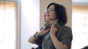 El experto de la moda muestra manera elegante y fácil de llevar un pañuelo para el cuello almacen de metraje de vídeo El experto de la moda muestra manera elegante y fácil de llevar un pañuelo para el cuello almacen de metraje de vídeo