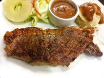 El filete de carne de vaca asó a la parrilla el filete con las especias y las fritadas y las verduras en una placa blanca fotografía de archivo El filete de carne de vaca asó a la parrilla el filete con las especias y las fritadas y las verduras en una placa blanca fotografía de archivo