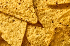El fondo del primer triangular amarillo de los nachos del maíz fotografía de archivo El fondo del primer triangular amarillo de los nachos del maíz fotografía de archivo