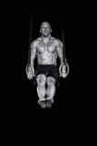 El gimnasta atractivo fuerte trabaja en los anillos El gimnasta atractivo fuerte trabaja en los anillos