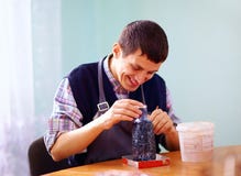 El hombre adulto joven con incapacidad enganchó a artesanía en prac Foto de archivo El hombre adulto joven con incapacidad enganchó a artesanía en prac Foto de archivo