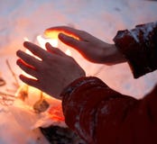 El hombre calienta las manos congeladas en el invierno por un fuego minúsculo foto de archivo libre de regalías El hombre calienta las manos congeladas en el invierno por un fuego minúsculo foto de archivo libre de regalías