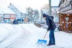 El hombre con la pala de la nieve limpia las aceras en invierno imágenes de archivo libres de regalías El hombre con la pala de la nieve limpia las aceras en invierno imágenes de archivo libres de regalías