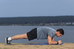 El hombre de la aptitud del entrenamiento de Crossfit que hace el ejercicio de la base del tablón que resuelve su base del midsec foto de archivo libre de regalías El hombre de la aptitud del entrenamiento de Crossfit que hace el ejercicio de la base del tablón que resuelve su base del midsec foto de archivo libre de regalías