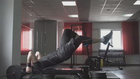 El hombre de la aptitud está mintiendo en el banco y aumenta sus piernas Entrenamiento cruzado de la base que resuelve los múscul almacen de video El hombre de la aptitud está mintiendo en el banco y aumenta sus piernas Entrenamiento cruzado de la base que resuelve los múscul almacen de video