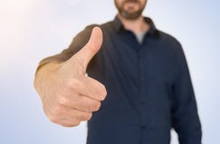 El hombre de negocios en la camisa azul que muestra los pulgares sube gesto fotos de archivo libres de regalías El hombre de negocios en la camisa azul que muestra los pulgares sube gesto fotos de archivo libres de regalías