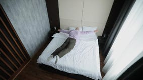 El hombre de negocios feliz salta en cama en la habitación de tener un resto metrajes El hombre de negocios feliz salta en cama en la habitación de tener un resto metrajes