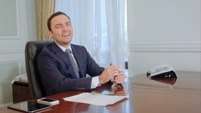 El hombre de negocios joven acertado cuenta el dinero, pareciendo feliz Foto de archivo libre de regalías El hombre de negocios joven acertado cuenta el dinero, pareciendo feliz Foto de archivo libre de regalías