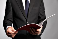 El hombre de negocios sostiene un folleto Imagenes de archivo El hombre de negocios sostiene un folleto Imagenes de archivo