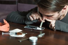 El hombre del adicto huele la cocaína de un espejo Fotografía de archivo libre de regalías El hombre del adicto huele la cocaína de un espejo Fotografía de archivo libre de regalías