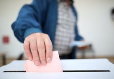 El hombre echa su votación en las elecciones foto de archivo libre de regalías El hombre echa su votación en las elecciones foto de archivo libre de regalías