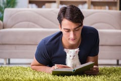 El hombre hermoso joven que juega con el gatito blanco imagen de archivo libre de regalías El hombre hermoso joven que juega con el gatito blanco imagen de archivo libre de regalías