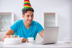 El hombre joven que celebra cumpleaños solamente en casa imagen de archivo El hombre joven que celebra cumpleaños solamente en casa imagen de archivo
