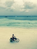El hombre monta la bicicleta en las playas de Zanzíbar Imagenes de archivo El hombre monta la bicicleta en las playas de Zanzíbar Imagenes de archivo