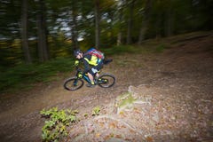 El hombre monta la e-bici cuesta abajo en rastro del bosque fotografía de archivo El hombre monta la e-bici cuesta abajo en rastro del bosque fotografía de archivo