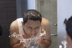 El hombre se lava la cara en cuarto de ba?o foto de archivo libre de regalías El hombre se lava la cara en cuarto de ba?o foto de archivo libre de regalías