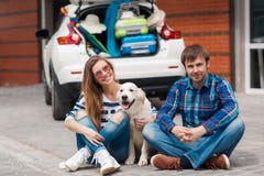 El hombre y la mujer con el perro en coche listo para el coche disparan fotografía de archivo El hombre y la mujer con el perro en coche listo para el coche disparan fotografía de archivo