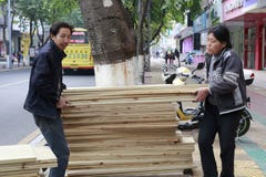 El hombre y la mujer llevan el tablón de la madera fotos de archivo El hombre y la mujer llevan el tablón de la madera fotos de archivo