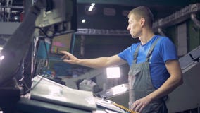 El ingeniero trabaja con el equipo industrial usando pantalla táctil almacen de video El ingeniero trabaja con el equipo industrial usando pantalla táctil almacen de video