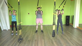 El instructor enseña en el gimnasio para practicar a un hombre en las bisagras del rato que realiza un empuje facial del ejercici almacen de metraje de vídeo El instructor enseña en el gimnasio para practicar a un hombre en las bisagras del rato que realiza un empuje facial del ejercici almacen de metraje de vídeo