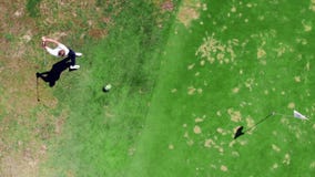 El jugador masculino está pegando una pelota de golf con fuerza en una visión superior metrajes El jugador masculino está pegando una pelota de golf con fuerza en una visión superior metrajes