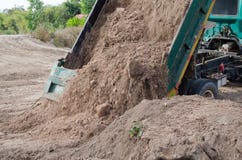 El llevar de los camiones volquete bueno llenando un campo, dando lugar a una aleta fotografía de archivo libre de regalías El llevar de los camiones volquete bueno llenando un campo, dando lugar a una aleta fotografía de archivo libre de regalías