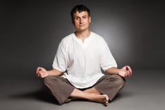 El meditar pacífico del hombre aislado sobre oscuridad Imagen de archivo libre de regalías El meditar pacífico del hombre aislado sobre oscuridad Imagen de archivo libre de regalías