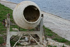 El mezclador concreto sucio viejo se coloca en la calle en la orilla del depósito Foto de archivo libre de regalías El mezclador concreto sucio viejo se coloca en la calle en la orilla del depósito Foto de archivo libre de regalías