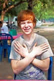 El muchacho con el pelo y la piqueta rojos en la cara parece feliz imagen de archivo El muchacho con el pelo y la piqueta rojos en la cara parece feliz imagen de archivo