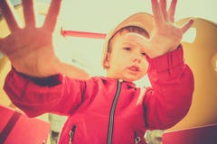 El muchacho de 3 años lindo juega emocionado en una diapositiva amarilla del patio en un día fresco fotos de archivo libres de regalías El muchacho de 3 años lindo juega emocionado en una diapositiva amarilla del patio en un día fresco fotos de archivo libres de regalías