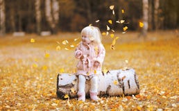 El niño de la foto de la forma de vida del otoño lanza para arriba las hojas y la diversión el tener Fotografía de archivo libre de regalías El niño de la foto de la forma de vida del otoño lanza para arriba las hojas y la diversión el tener Fotografía de archivo libre de regalías