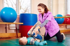 El niño lindo con incapacidad tiene terapia musculoesquelética haciendo ejercicios en correas de la fijación del cuerpo imágenes de archivo libres de regalías El niño lindo con incapacidad tiene terapia musculoesquelética haciendo ejercicios en correas de la fijación del cuerpo imágenes de archivo libres de regalías