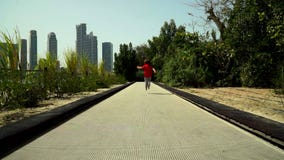 El niño pequeño divertido corre y salta en la pista del trampolín en el parque almacen de metraje de vídeo El niño pequeño divertido corre y salta en la pista del trampolín en el parque almacen de metraje de vídeo