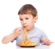 El niño pequeño está comiendo los espaguetis fotografía de archivo El niño pequeño está comiendo los espaguetis fotografía de archivo