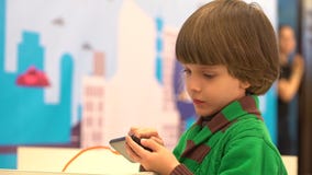 El niño pequeño lindo utiliza un smartphone El robot demostró para los niños en el 4to festival ruso de la ciencia El evento esta metrajes El niño pequeño lindo utiliza un smartphone El robot demostró para los niños en el 4to festival ruso de la ciencia El evento esta metrajes