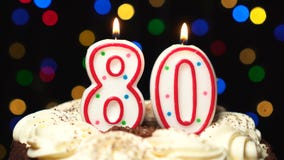 El número 80 encima de la torta - burning de la vela de ochenta cumpleaños - sople hacia fuera en el extremo Fondo borroso color almacen de metraje de vídeo El número 80 encima de la torta - burning de la vela de ochenta cumpleaños - sople hacia fuera en el extremo Fondo borroso color almacen de metraje de vídeo