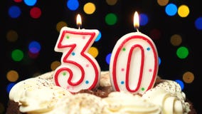El número 30 encima de la torta - burning de la vela de treinta cumpleaños - sople hacia fuera en el extremo Fondo borroso color almacen de metraje de vídeo El número 30 encima de la torta - burning de la vela de treinta cumpleaños - sople hacia fuera en el extremo Fondo borroso color almacen de metraje de vídeo